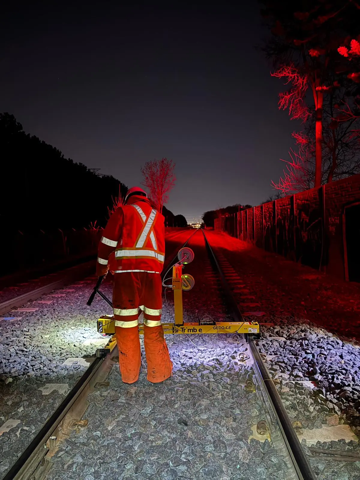 Summit field crew operating a GEDO trolley during a nighttime rail survey in Toronto